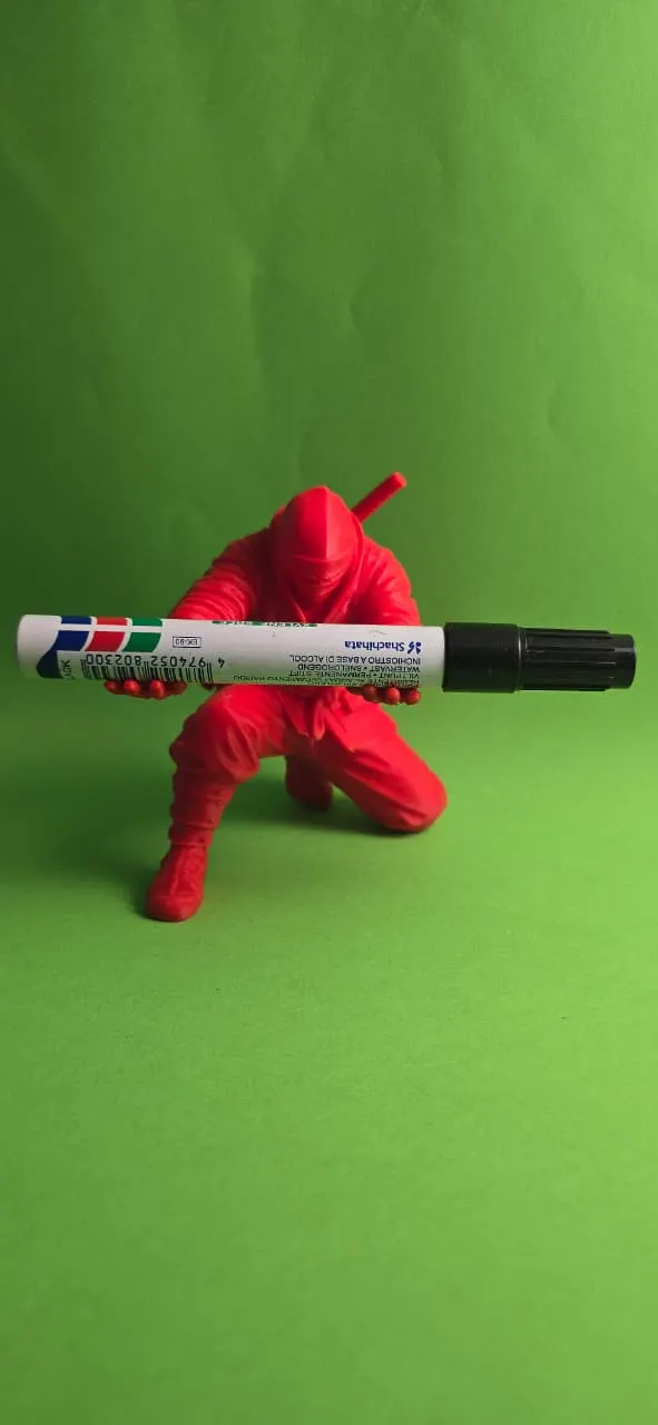 Red ninja figure holding a marker pen
